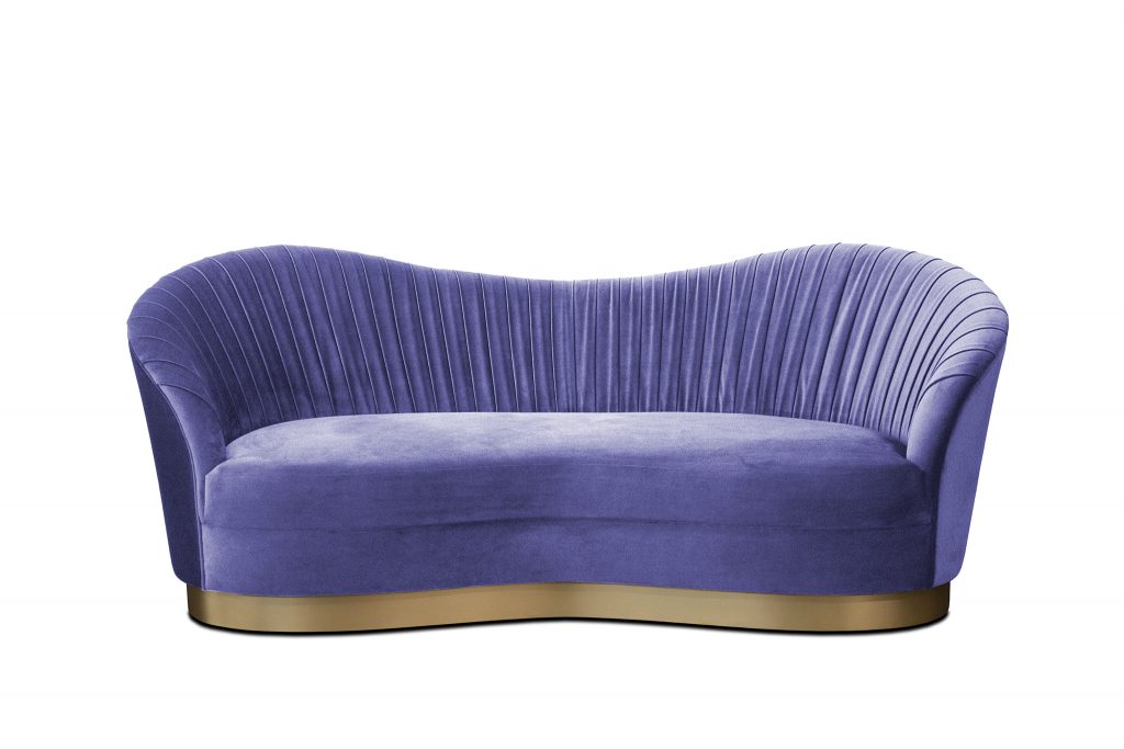 Kelly Sofa: Its fluid curves are harmoniously matched by sumptuous pleated waves of soft upholstery fabric. Has a striking metal band hugging the base of her curvaceous body, leaving you constantly searching for a golden glimpse of her copious beauty.