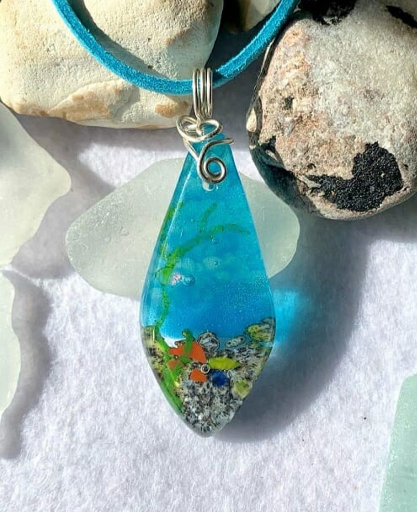 Seascape Fused Glass Necklace, Underwater Coral Reef Style by Fulfilled Wishes

A glimpse into an underwater world, this hand crafted fused glass art necklace looks just as if you could swim on in to it! It is created with layers of different glass and multiple fusings to build up the 3D effect.