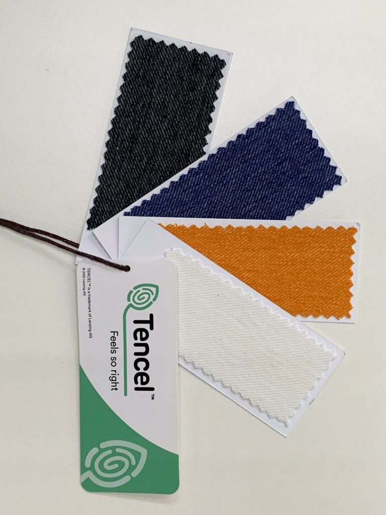 Close-up image of TENCEL™ hangtag with different colored cloth.