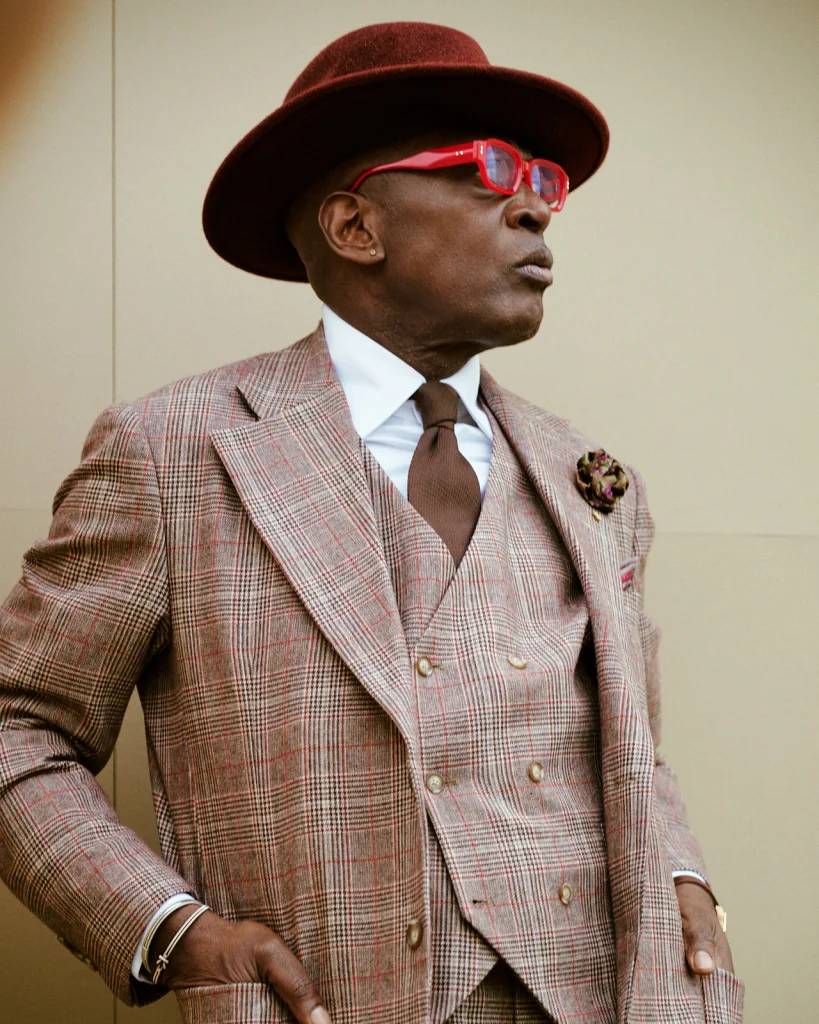 Brown Checked Three-Piece Suit with Brown Tie / White Cotton Poplin Shirt with Double Cuffs and Contrast Collar / Brown Suede Loafers with Tassels A classic proposal with sartorial character. The check pattern adds visual dynamism, while the three-piece set reinforces structure and elegance. The brown tie maintains color harmony for a refined and coherent look. (Image credits Thierry Mouele @thierrymouelelasprezzatura Styled by Hockerty, Photo courtesy of Hockerty https://www.instagram.com/hockerty_official/