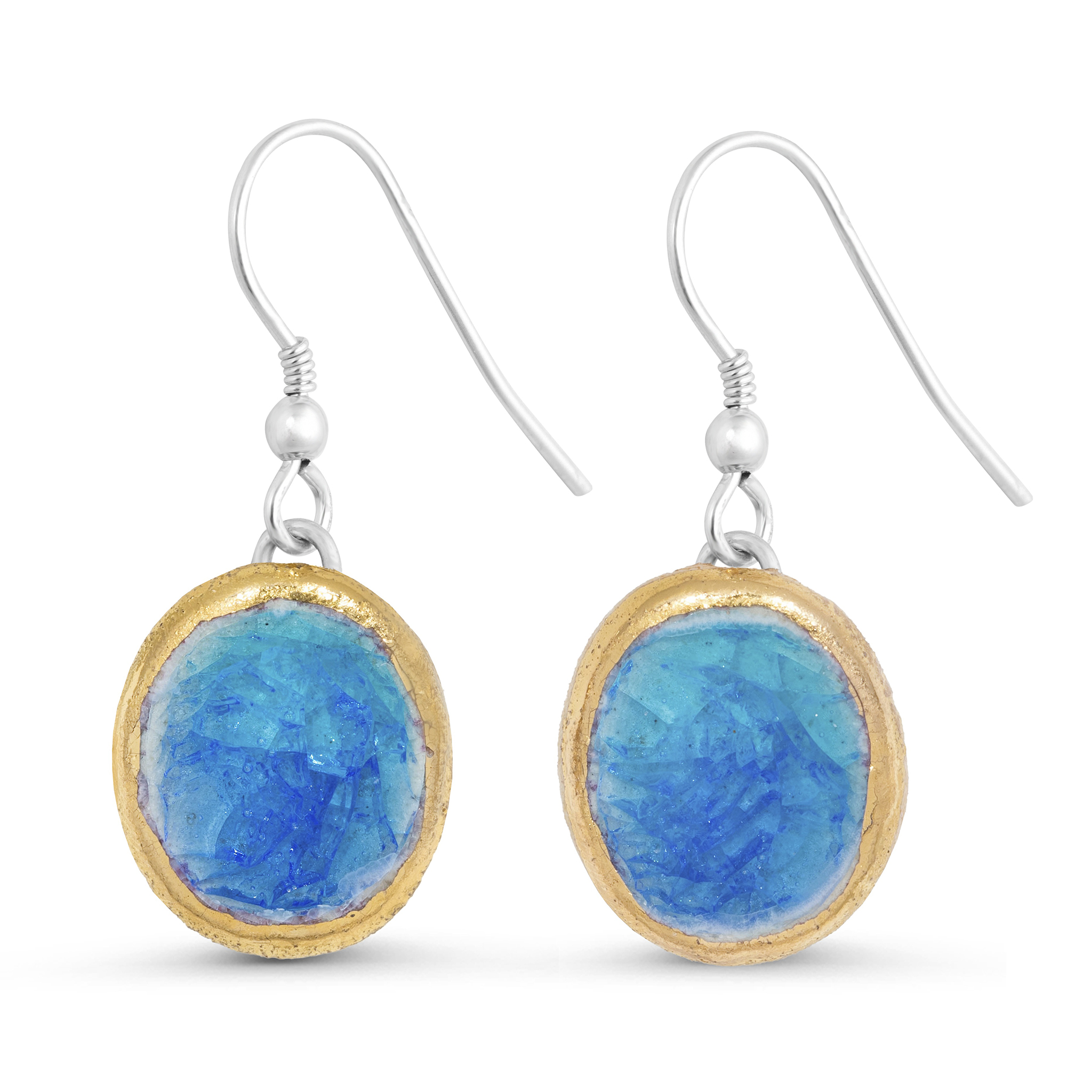 Turquoise Blue Lagoon Oval Drop Earrings Habulous presents elegant oval drop earrings in vibrant blue tones, inspired by the calm movement of water. Designed to bring a fresh pop of color, they offer a refined yet expressive addition to any jewellery collection. Handcrafted from ceramic and glass, and finished with real gold lustre detailing, each piece is carefully shaped and painted by hand. The earrings are completed with sterling silver hooks for comfortable wear. Each pair is entirely unique, with natural variations in color and finish. Over time, the outer edge of the gold detailing may gently fade, revealing the ceramic beneath. Care instructions should be followed to preserve the finish. Approximate dimensions: 1.8 cm (length) x 1.4 cm (width).